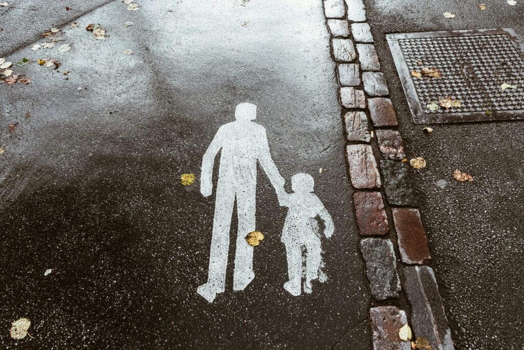 Sidewalk markings of parent and child on a rainy day