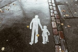 Sidewalk markings of parent and child on a rainy day